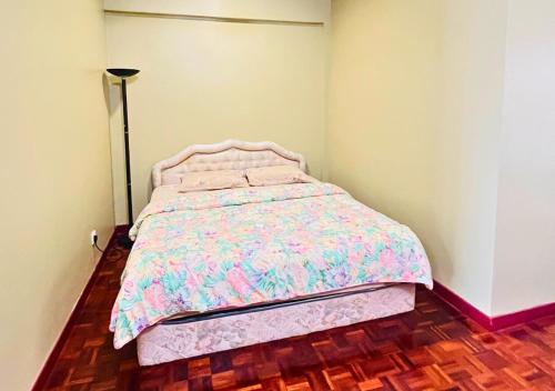 a small bedroom with a bed with a pink comforter at Penthouse Seafront View PD in Port Dickson