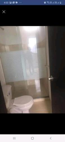 bagno con servizi igienici bianchi e finestra di Apto 414 a Cúcuta