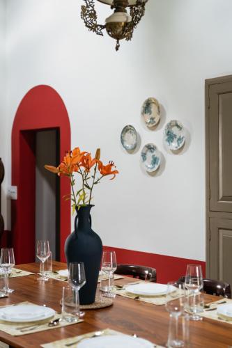 a table with a vase with flowers in it at Casa Desa Monteiro 4BHK Stand Alone Villa In Diwar Island with Complementary Breakfast & Private Pool, Garden, Fully Equipped Kitchen in Divar