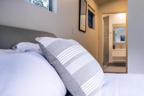 a bedroom with a bed with two pillows at Driftwood in Coles Bay