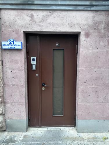 Una puerta marrón en un edificio con un cartel. en Garden Lounge Hotel en Ereván