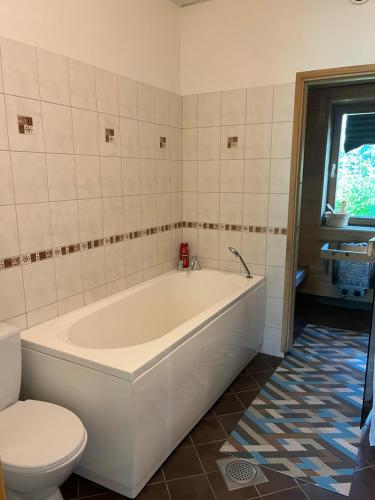 a bathroom with a white tub and a toilet at Cosy house in Center of Tartu in Tartu