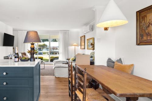 a kitchen and living room with a wooden dining room table at The Waratah Cottage in Robertson