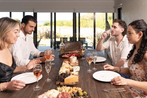 a group of people sitting around a table with wine glasses at Southbeach - Direct Beach Access To Jones Beach in Kiama Downs