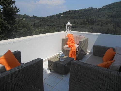 a balcony with two chairs and an orange scarf on it at Villa Fedrita in Acharavi