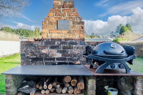a brick barbecue with a helmet on top of it at The Waratah Cottage in Robertson