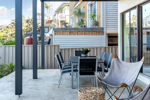 an outdoor patio with a table and chairs at Southbeach - Direct Beach Access To Jones Beach in Kiama Downs