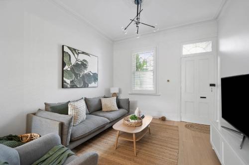 a living room with a couch and a tv at 'The Enmore' - in the heart of everything Newtown in Sydney