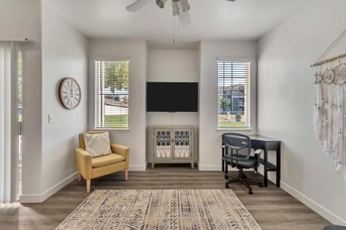 a living room with a tv and a chair and a desk at Mountain View by Cloud Dream Homes in Clearfield