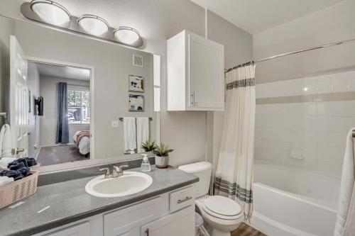 La salle de bains blanche est pourvue d'un lavabo et de toilettes. dans l'établissement Luxe Main Floor Family Friendly Apt King Beds, à Clearfield