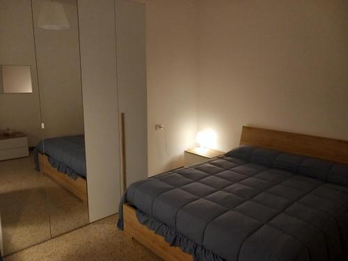 1 dormitorio con cama azul y espejo en Relax en Bolonia