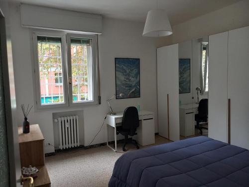 1 dormitorio con 1 cama, escritorio y ventanas en Relax, en Bolonia