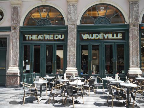 a restaurant with tables and chairs in front of it at Le Vaudeville in Brussels