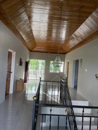a living room with a wooden ceiling and a staircase at The Retreat in Lyssons