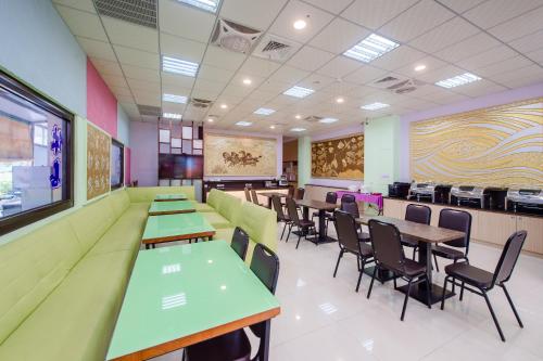 a dining room with green tables and chairs at Quan Ming B&B in Dahu