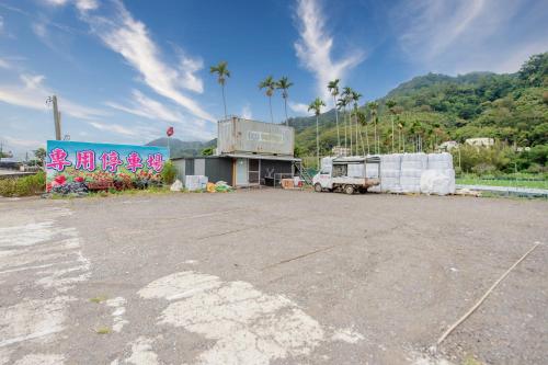 an empty parking lot with a truck parked in front of a building at Quan Ming B&B in Dahu