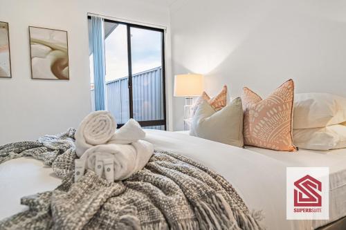 a bedroom with a large white bed with pillows at Bunbury Beach Splendor Modern Coastal Home in Bunbury