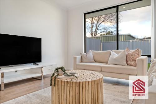 a living room with a tv and a couch at Bunbury Beach Splendor Modern Coastal Home in Bunbury