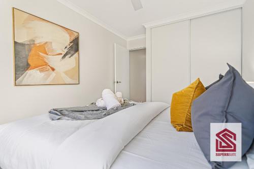 a bedroom with a white bed and a large window at Bunbury Beach Splendor Modern Coastal Home in Bunbury