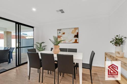 a dining room with a white table and chairs at Bunbury Beach Splendor Modern Coastal Home in Bunbury