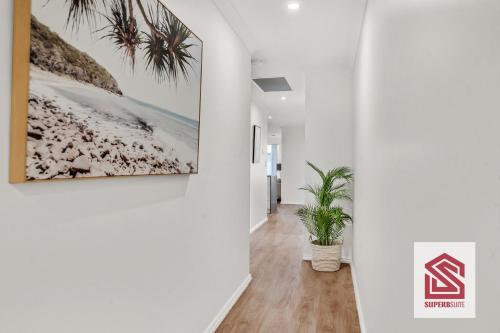 a hallway with a picture of the beach and a painting on the wall at Bunbury Beach Splendor Modern Coastal Home in Bunbury