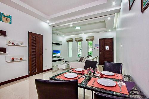 a dining room with a table and chairs and a living room at Baan Noppadol Hua Hin Resort in Hua Hin