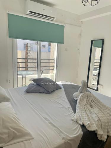een slaapkamer met een groot wit bed en een raam bij Mad beach in Protaras