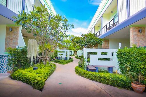 a courtyard of a building with a bench and trees at Baan Noppadol Hua Hin Resort in Hua Hin