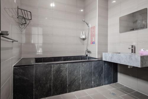 a bathroom with a bath tub and a sink at Quan Ming B&B in Dahu
