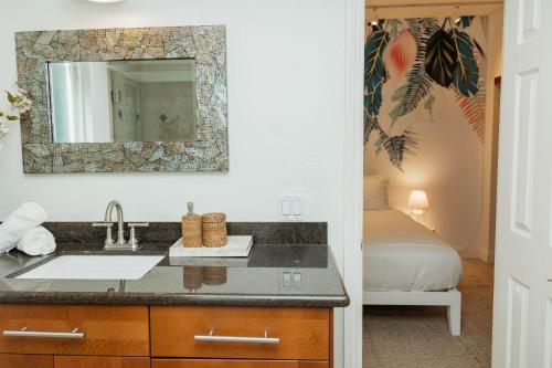 uma casa de banho com um lavatório, um espelho e uma cama em Dreamy Pb Home - Walk To Bay And Beach em San Diego