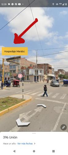 una foto de una calle con un pájaro rojo en un cartel en Hospedaje Marabú en Chiclayo