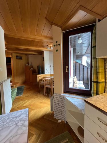 une cuisine et une salle à manger avec une grande fenêtre dans l'établissement Little King - Feel like at home, à Kranjska Gora