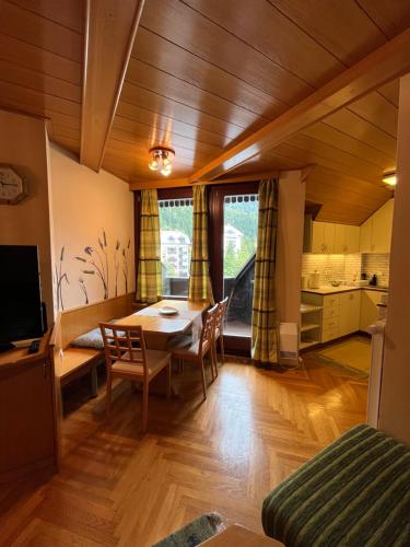 uma sala de estar com uma mesa e uma cozinha em Little King - Feel like at home em Kranjska Gora