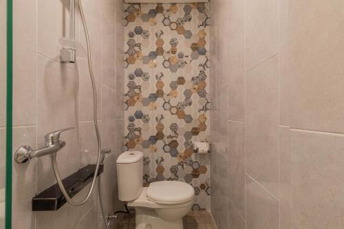 a bathroom with a toilet and a shower at The Baliem Hotel in Jimbaran