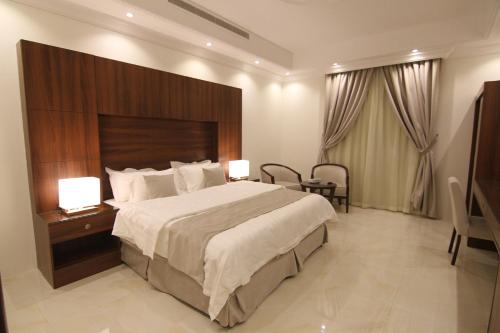 a hotel room with a large bed and a table at East Diamond Serviced Apartments in Jeddah