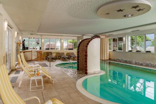 a swimming pool in a hotel room with a swimming pool at Panoramahotel Gürtl in Haus im Ennstal