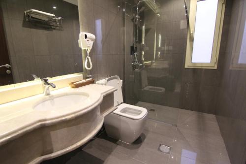 a bathroom with a sink and a toilet and a shower at East Diamond Serviced Apartments in Jeddah
