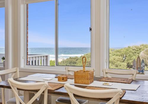 a dining room with a table and chairs and a view of the ocean at Paradise on Jones Beach Kiama - Beachfront unit with direct beach access & views in Kiama Downs