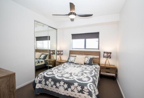 a bedroom with a bed and a ceiling fan at Time n Tide - Straddie Beach House in Point Lookout