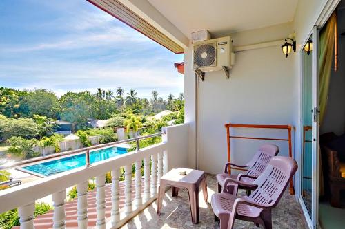 a balcony with two chairs and a swimming pool at Maikhao Beach Residence in Mai Khao Beach
