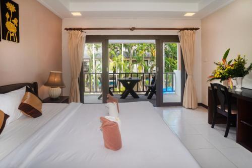 a bedroom with a bed and a balcony at The Florist Resort in Mae Nam