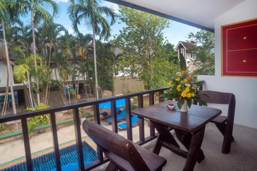 a balcony with a table and chairs and a pool at The Florist Resort in Mae Nam