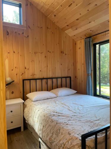 sypialnia z łóżkiem w drewnianej ścianie w obiekcie Vermont Scandinavian Chalet-Brévent w mieście Wolcott