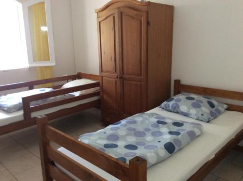 um quarto com duas camas e um armário em La case vétyver em Saint-Joseph