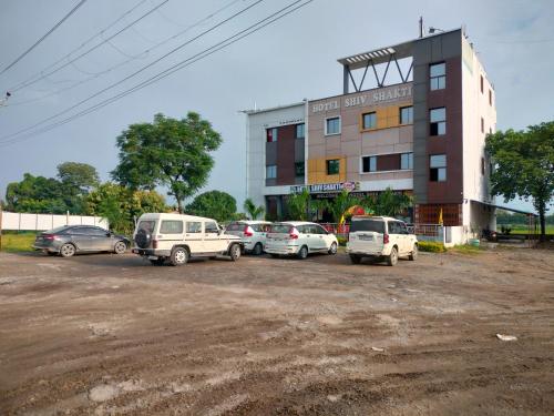 un grupo de coches estacionados frente a un edificio en Hotel Shiv Shakti en Mohaniā