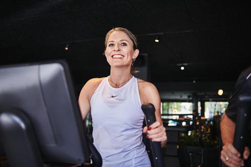 a woman standing in a gym holding a hair dryer at Hotel Zugbrücke Grenzau GmbH in Höhr-Grenzhausen