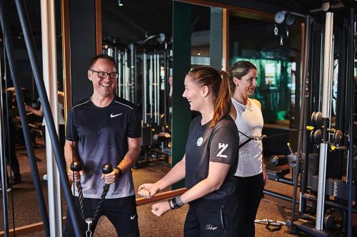 a man and two women standing in a gym at Hotel Zugbrücke Grenzau GmbH in Höhr-Grenzhausen