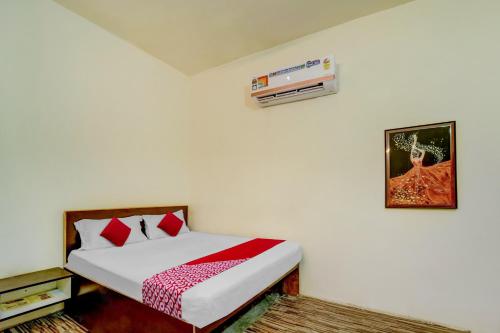 a bedroom with a bed with red pillows at OYO Flagship Hotel The Olive Stay in Patna