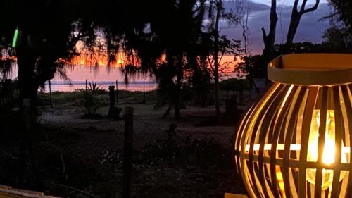 a yellow vase with a sunset in the background at La Villa l'Ancre Marine, pieds dans le lagon ! in La Saline les Bains