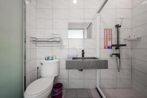 a bathroom with a toilet and a sink at Quan Ming B&B in Dahu